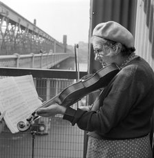 Busker playing the violin, Hungerford Bridge, Lambeth, London, c1946-c1959. Artist: John Gay
