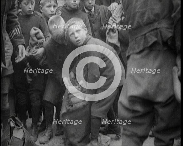 Children Dressed in Scruffy Clothes Gathering Fire Wood Into Sacks, 1920. Creator: British Pathe Ltd.