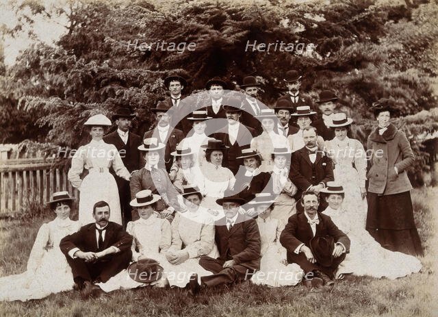 A group of hospital staff, including nurses wearing matching straw hats, standing outdoors. Creator: Unknown.