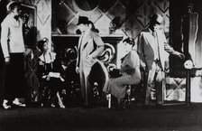 Three men standing, two women sitting, 1935 - 1939. Creator: Milton Meltzer.