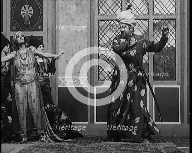 Scene from the Play 'Hassan': the Actor Henry Ainley in Full Costume Raising a Sword..., 1920s. Creator: British Pathe Ltd.