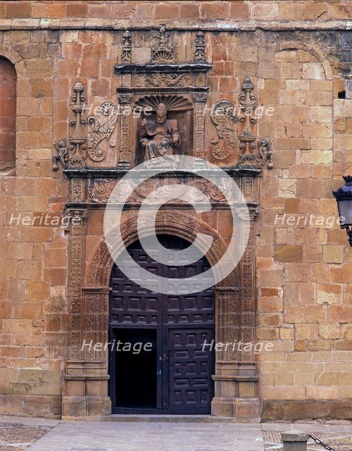 Front door of St. Peter's Cathedral, crowned by the seated image of Saint Peter Pope, embedded in…