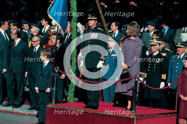 Juan Carlos I, King of Spain, with Queen Sofia and Prince Felipe, presiding over a military parad…