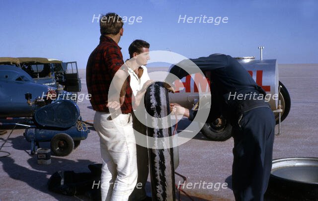 Mechanics inflating Bluebird CN7 tyre for World Land Speed Record attempt, Lake Eyre, 1964. Creator: Unknown.