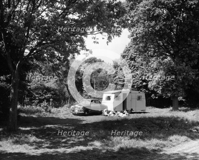 A family relaxing on holiday with their 1951 Vauxhall Wyvern and caravan, (1951?). Artist: Unknown