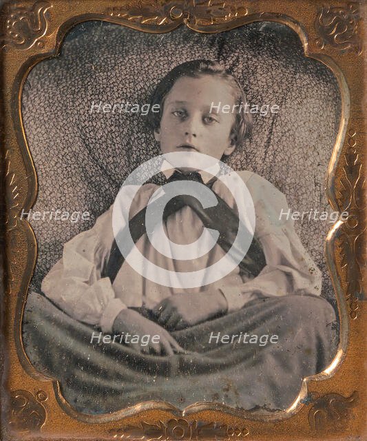Boy Seated Cross-legged, Partially Covered by Blanket, Leaning Against Cushion, 1850s. Creator: Unknown.