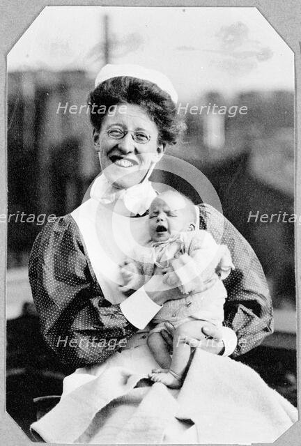 General Lying In Hospital, York Road, Lambeth: nurse sitting holding baby, 1906. Creator: Unknown.
