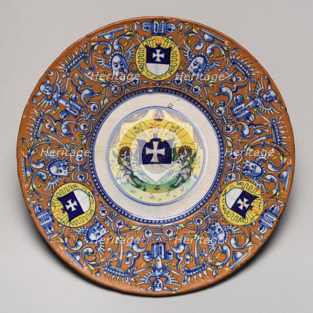 Plate with border of grotesques on an orange ground and three shields..., probably c1510/1525. Creator: Unknown.
