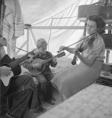 Migrant family from Arkansas playing hill-billy songs, FSA...migratory camp, Calipatria, CA, 1939. Creator: Dorothea Lange.