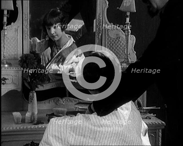 Female Civilian Having Her Hair Cut Into a 'Shingle' by a Male Civilian Hairdresser, 1920. Creator: British Pathe Ltd.
