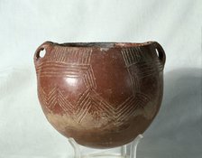 Red ochre glass (painted with a red slip of iron oxide), with incised parallel lines that form ge…