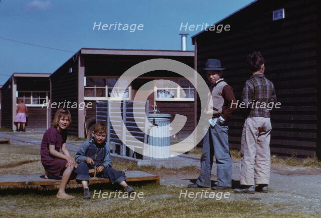 Boy building a model airplane while other children look on, FSA labor camp, Robstown, Tex., 1942. Creator: Arthur Rothstein.