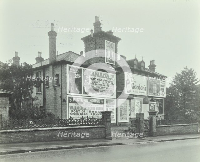 Advertising hoardings on the wall of a building, Wandsworth, London, 1938. Artist: Unknown.