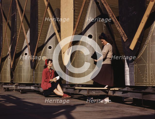 Girl inspectors at the Long Beach, Calif., plant of Douglas Aircraft Company make a careful..., 1942 Creator: Alfred T Palmer.