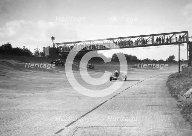 Cars racing on Byfleet Banking during the BRDC 500 Mile Race, Brooklands, 3 October 1931. Artist: Bill Brunell.