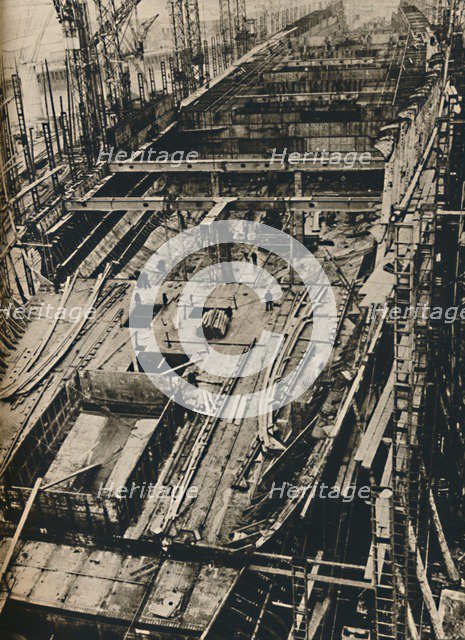 'More than 1,000 Feet Long. Shell of Queen Mary in early days of construction',  1930-1934, (1936). Artist: Unknown.