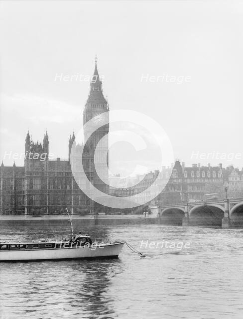 Boat passing along the Thames in front of Big Ben and the Houses of Parliament, London, c1955. Creator: Arthur Charles Kirby Ware.