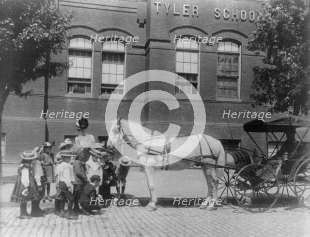 Children studying a horse and buggy outside the Tyler School, Washington, D.C., (1899?). Creator: Frances Benjamin Johnston.