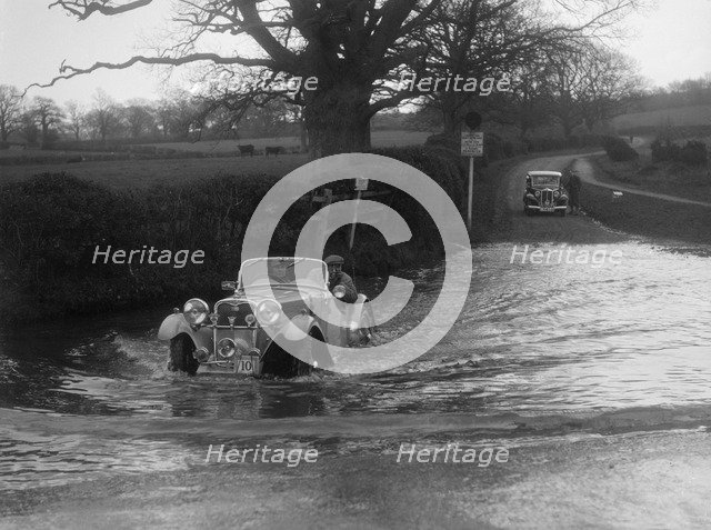 972 cc Singer Le Mans driving through a ford during a motoring trial, 1936. Artist: Bill Brunell.