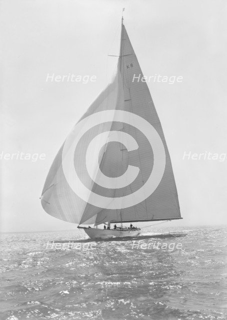 The 23 Metre 'Candida' (K8) sailing with spinnaker, 1935. Creator: Kirk & Sons of Cowes.