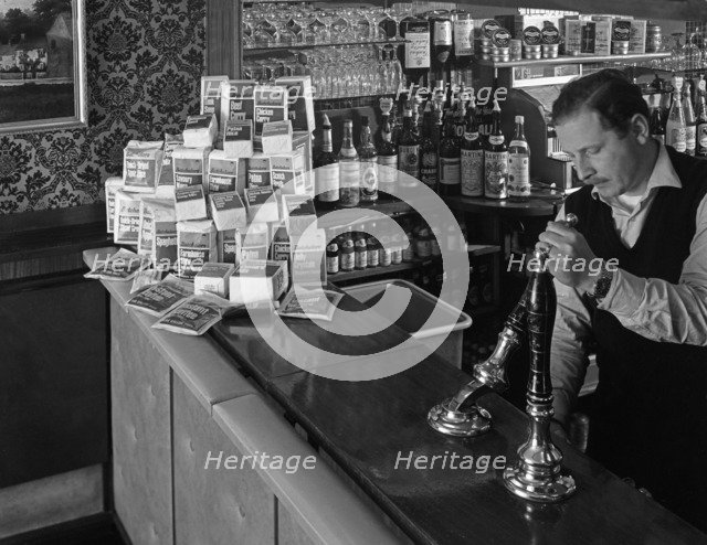 A pub landlord with a display of the Batchelors 5 day catering pack on his bar, 1968. Artist: Michael Walters