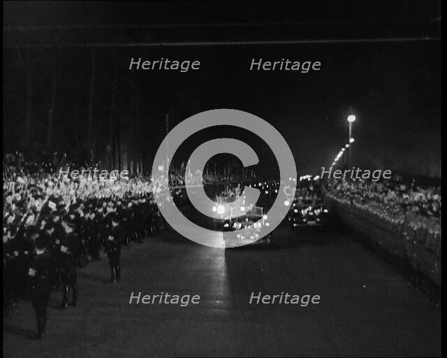 Nazi Party Staff Cars Driving Down a Wide Road in Berlin Edged With...Soldiers..., 1937 Creator: British Pathe Ltd.
