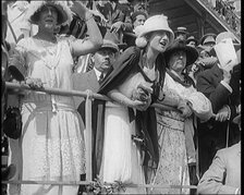 A Large Crowd of Civilians Wearing Smart Outfits and Hats Watching a Horse Race, 1920. Creator: British Pathe Ltd.