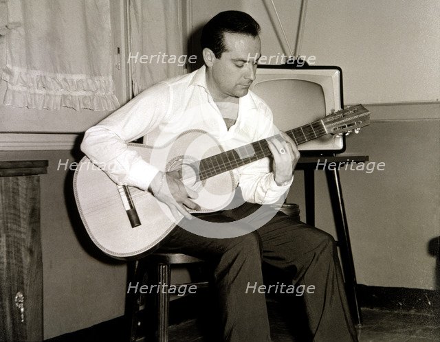 Ramon Calduch, Spanish singer playing guitar at home, 1967.