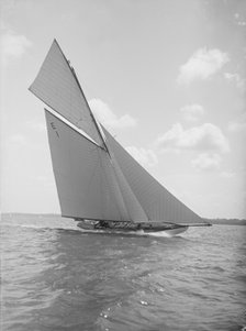 The 12 Metre yacht 'Alachie' makes swift progress upwind, 1911. Creator: Kirk & Sons of Cowes.