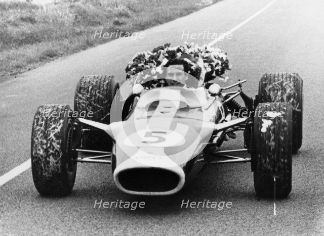 Jim Clark in a Lotus with the winner's laurel wreath. Artist: Unknown