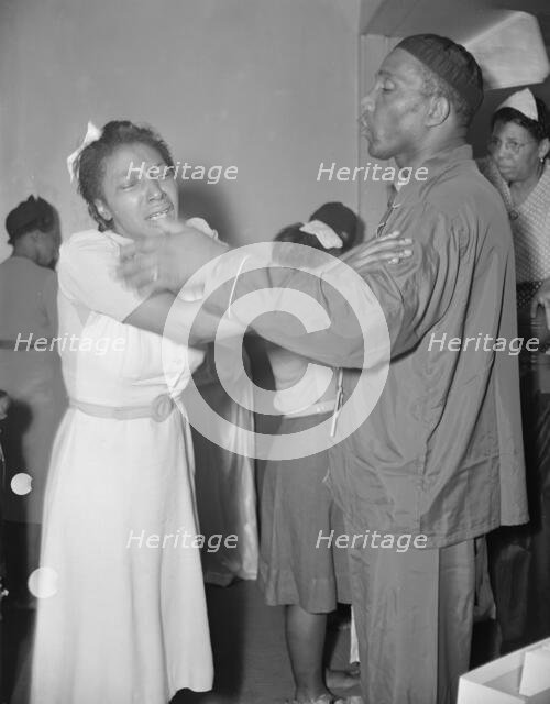 A member of the St. Martin's Spiritual Church, receiving the final..., Washington, D.C., 1942. Creator: Gordon Parks.