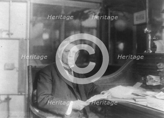 Man (banker?) seated at desk at American Security and Trust Co., Washington, D.C., c1890 - c1950. Creator: Frances Benjamin Johnston.