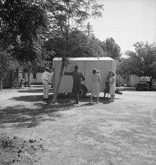 Family inspect a house trailer with idea of purchase, between Tulare and Fresno on U.S. 99, 1939. Creator: Dorothea Lange.