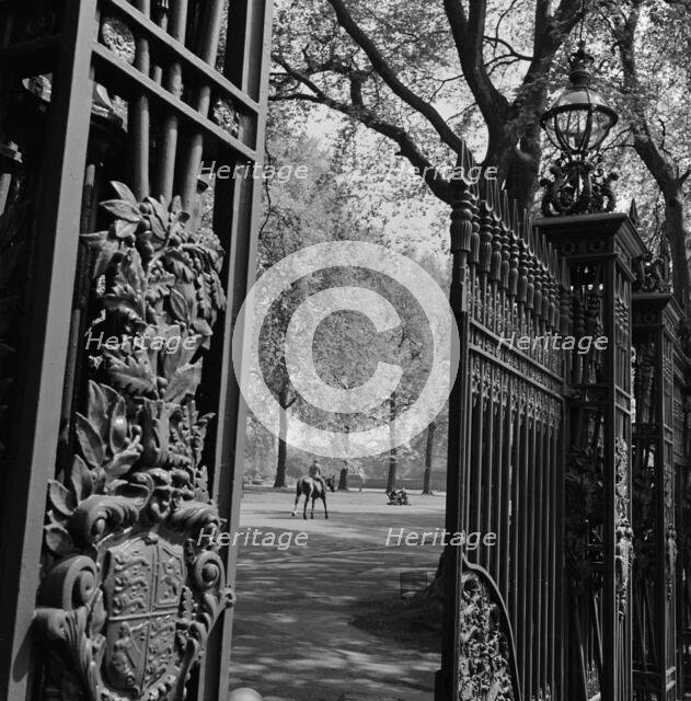 A view through one of the five pairs of elaborate cast iron gates, Queen's Gate, Hyde Park, 1955-65 Creator: John Gay.