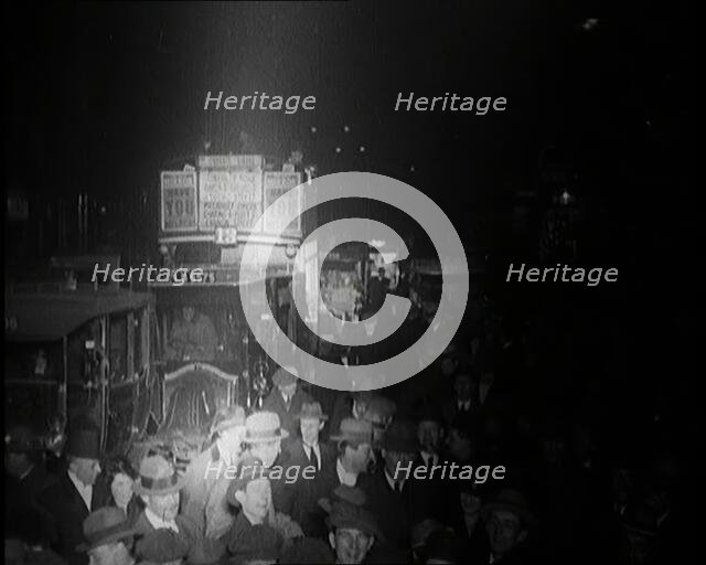 Buses and Crowds of People on a Busy London Street at Night, 1920s. Creator: British Pathe Ltd.
