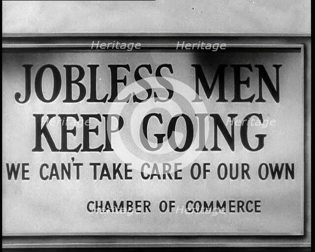 Sign reads: 'Jobless Men Keep Going - We Can Take Care of Our Own - Chamber of Commerce', 1932. Creator: British Pathe Ltd.