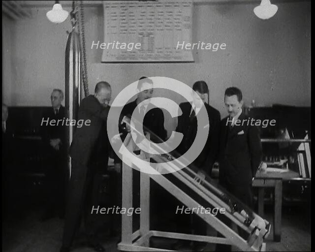 Interior Shot of a British Man Inserting Various Items in a Long Thin Glass Time Capsule..., 1938. Creator: British Pathe Ltd.