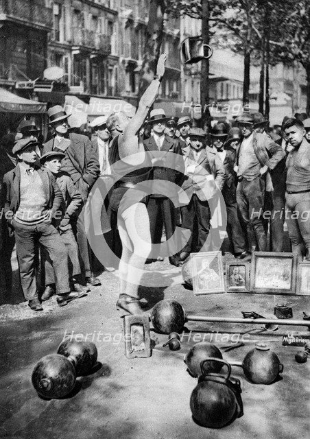 Strongman juggling with weights, Paris, 1931.Artist: Ernest Flammarion