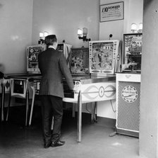Man playing pinball in a London amusement arcade, c1966-67. Artist: Henry Grant