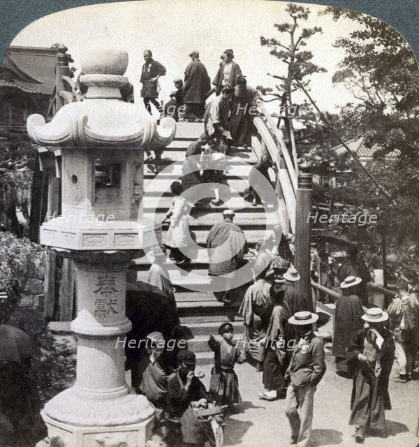 Worshippers crossing the semi-circular bridge to Kameido Temple beyond, looking north, Tokyo, Japan,Artist: Underwood & Underwood