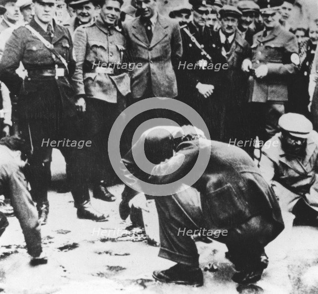 Jews are made to clean the streets of Vienna after the Anschluss, 1938. Artist: Unknown