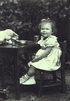 Portrait of a young girl seated at an outdoor table, facing front, between 1940 and 1950. Creator: Joseph Woodson Whitesell.