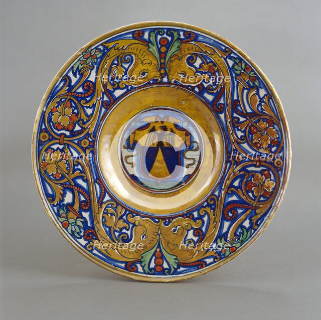 Plate with border of foliate scrollwork with dolphin heads and cornucopias; in the center..., 1524. Creator: Giorgio Andreoli workshop.