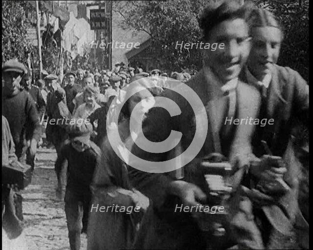 A Crowd Running up a Hilly Cobbled Street, 1920. Creator: British Pathe Ltd.
