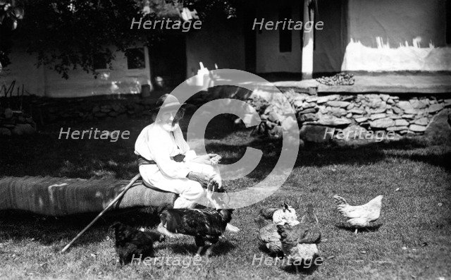 Old man feeding chickens, Bistrita Valley, Moldavia, north-east Romania, c1920-c1945. Artist: Adolph Chevalier