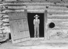 North Carolina farm boy in doorway of tobacco barn, Person County, North Carolina, 1939. Creator: Dorothea Lange.