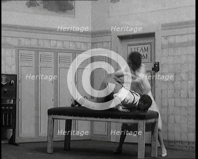 Scene from a Stage Show: Leslie Henson Being Given a Rough Massage and Having His Head..., 1920s. Creator: British Pathe Ltd.