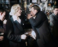 A British Woman and a British Man Standing at  the Bar Holding Drinks in a Public House..., 1939. Creator: British Pathe Ltd.