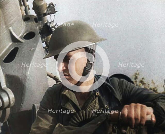 Close up of a Male British Soldier Wearing a Steel Helmet and Sitting Next to an Anti-Air..., 1939. Creator: British Pathe Ltd.