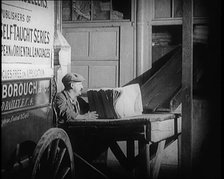 A Man Loading Bundles of Newspapers Into a Van, 1921. Creator: British Pathe Ltd.